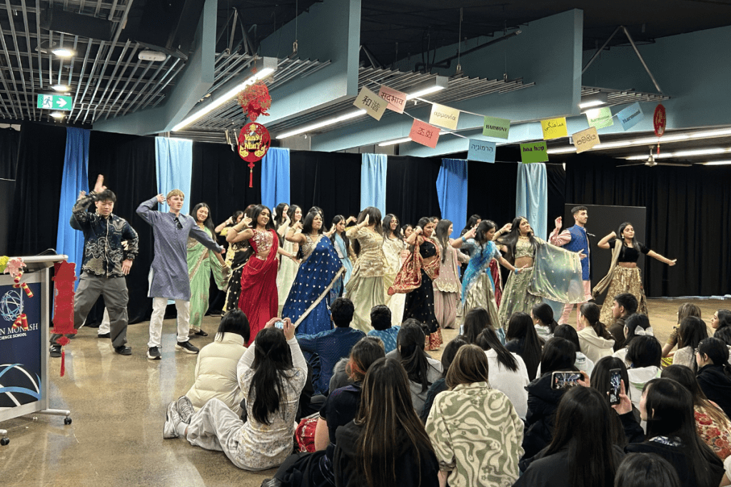 a group of students performing a bollywood dance on stage