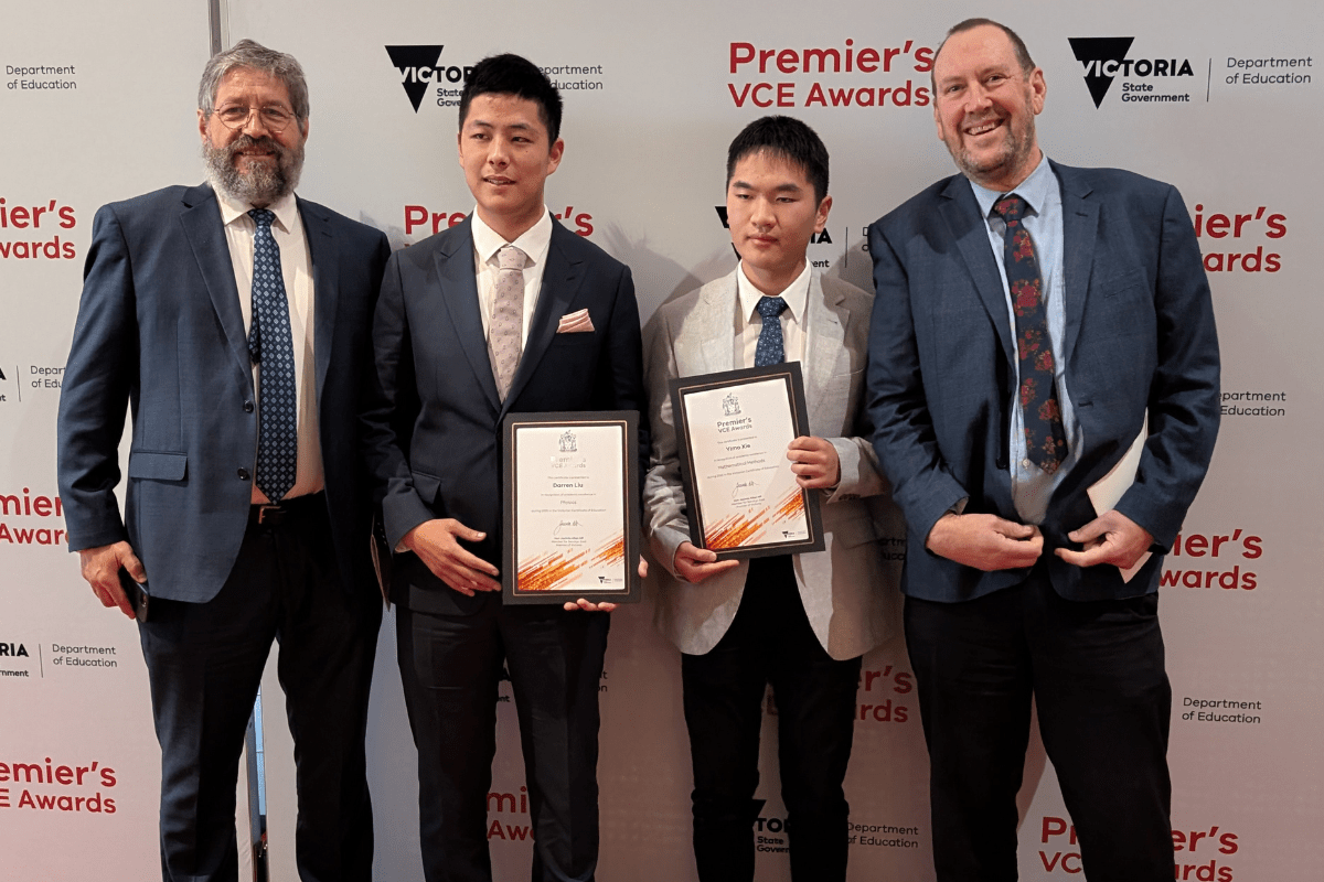 Four people posing in front of a banner saying VCE award 2026