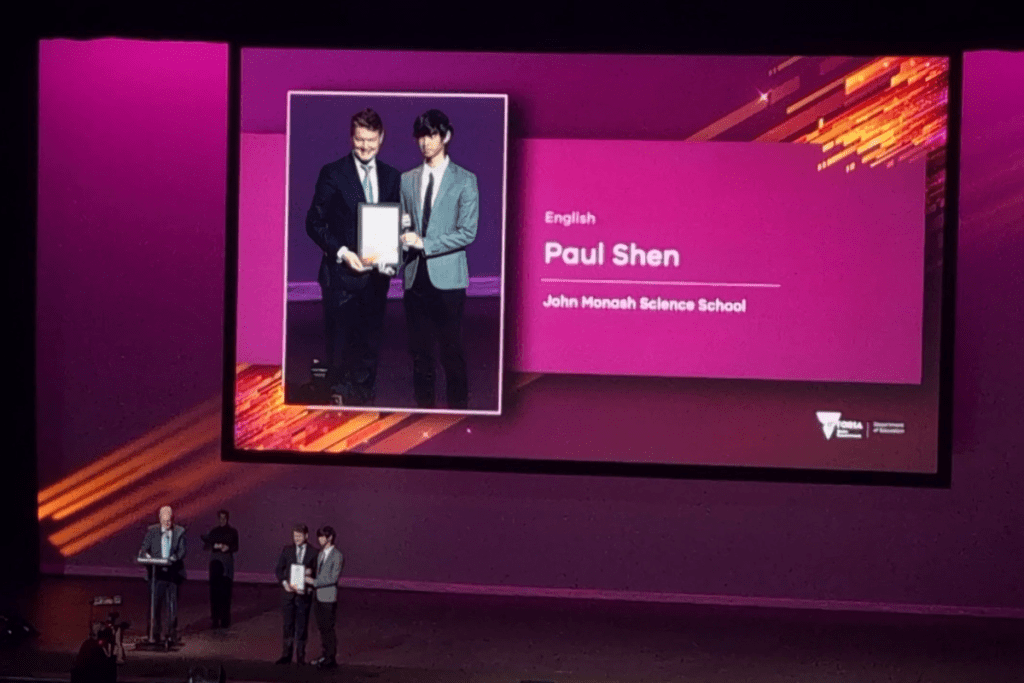 A long shot of some people standing on a stage during an award ceremony